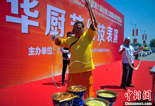 中华厨艺绝技表演现场，一位厨师正在展示蒙眼拉面的绝活。刘新　摄